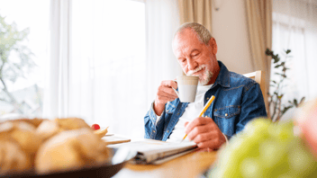 elderly man at home using crossword