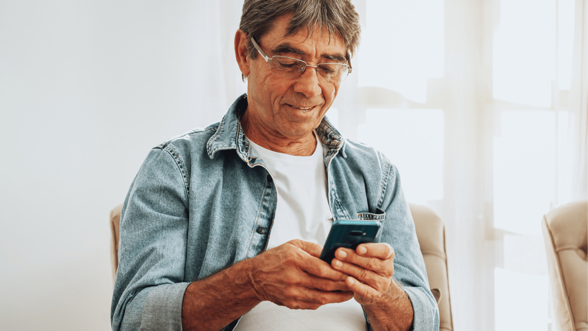 senior man using smartphone at home 