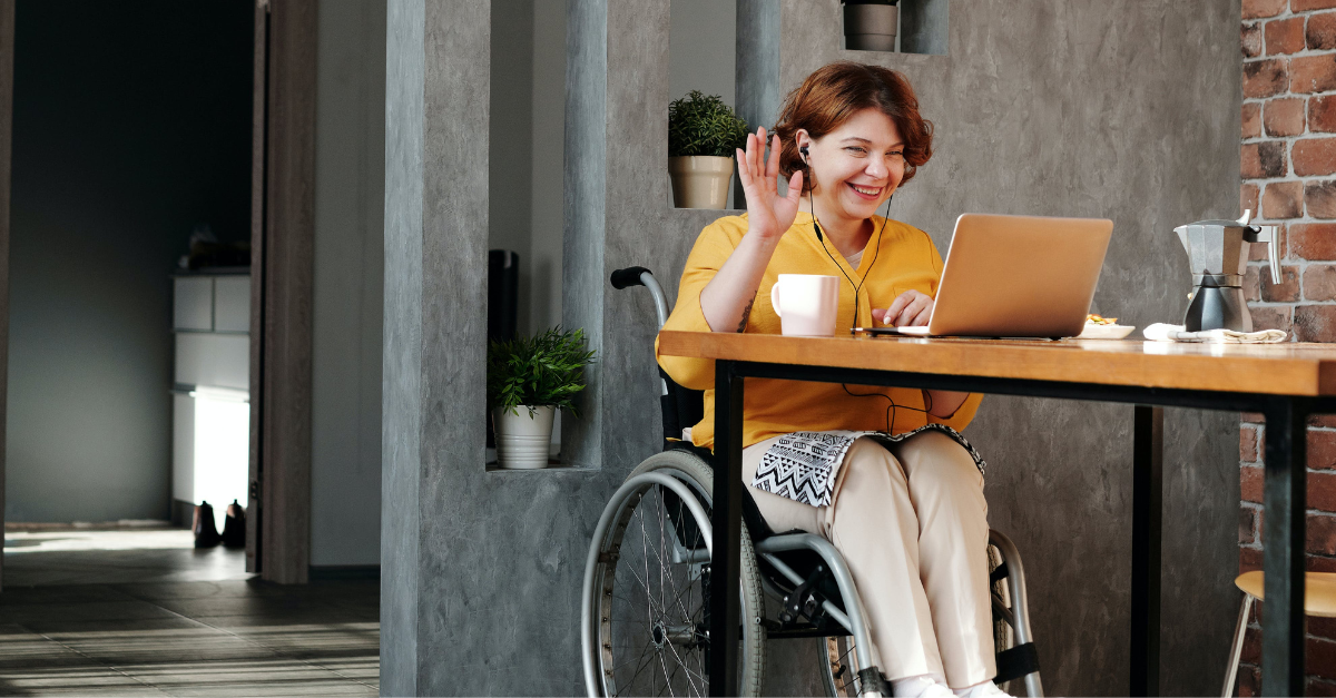 women in wheelchair at home on laptop 