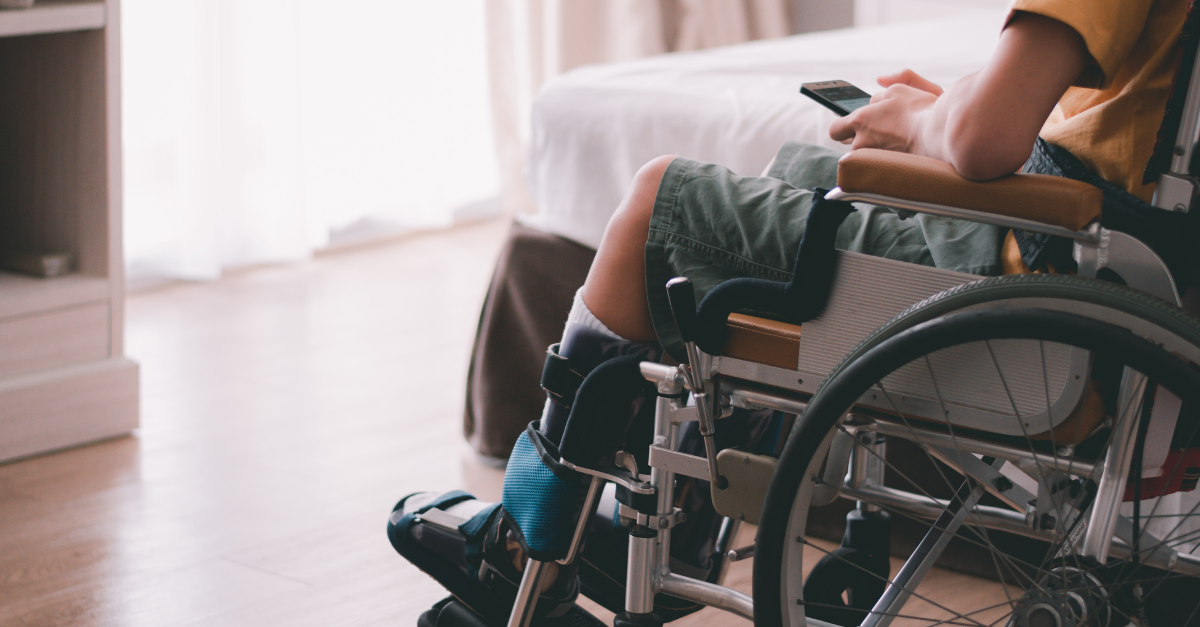 young person in wheelchair using phone