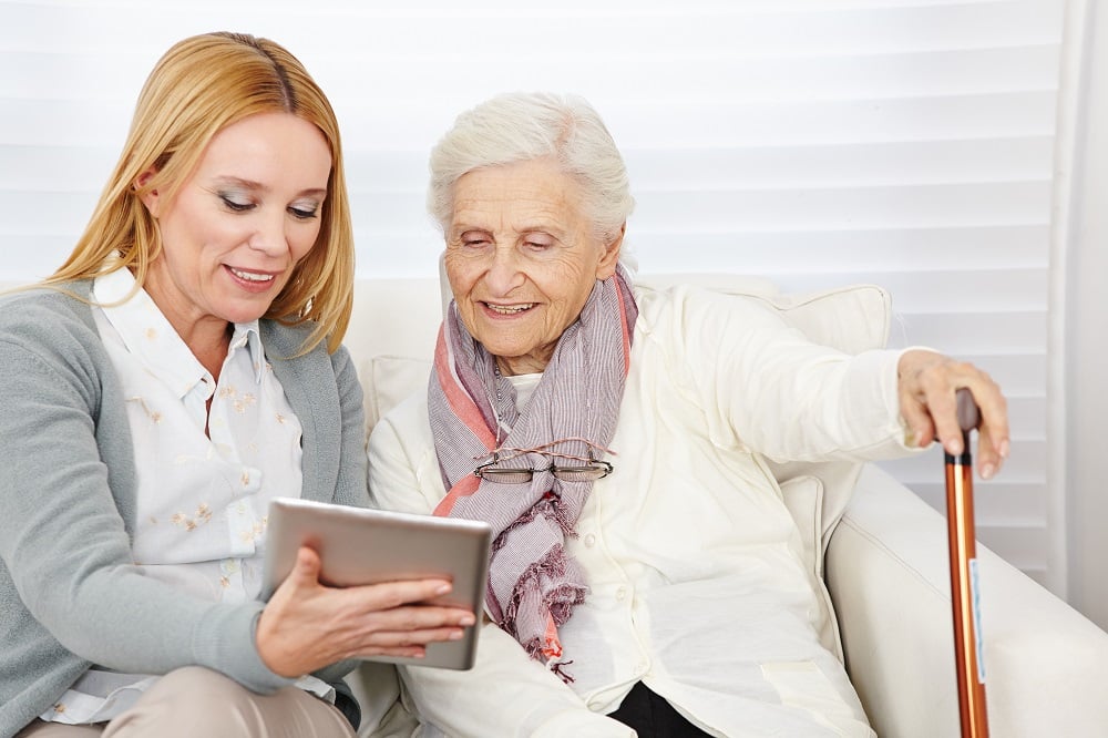 older person using Assistive Living Technology in the form of a tablet device