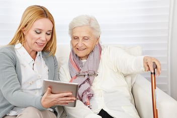 older person using Assistive Living Technology in the form of a tablet device